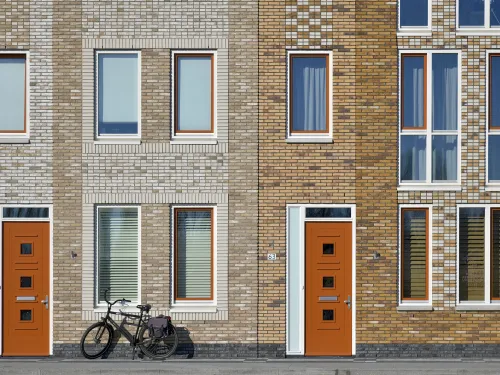 Voordeuren met fiets voor een huis