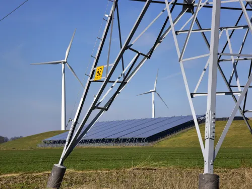 Landschap met hoogspanningsmast, windturbines en zonnepanelen