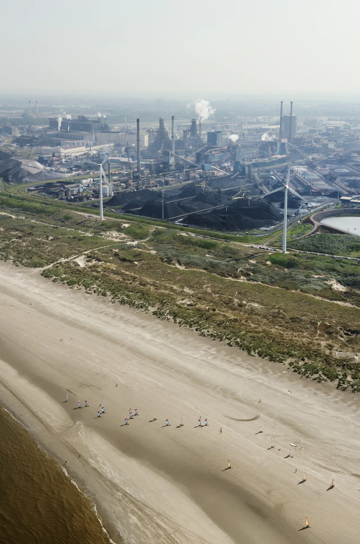 Luchtfoto van industrie en strand bij Wijk aan Zee