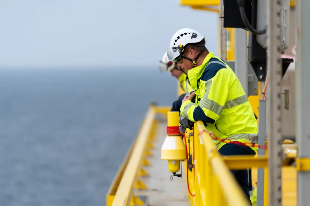 personen met bouwhelmen op een boorplatform op zee